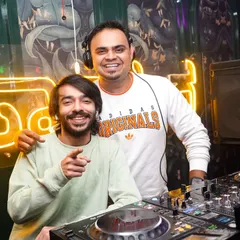 Sharing a smile with a fellow artist behind the decks. The camaraderie and mutual respect in the DJ community is one of the best parts of the job.