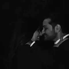 An intimate, low-light portrait. The focus is entirely on the couple's close connection, creating a romantic and moody photograph that feels very personal.