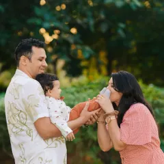 A playful and tender moment between parents and their baby during an outdoor family photoshoot. The mother kissing her baby's foot is a perfect example of the candid love I aim to capture.