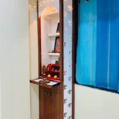 The doors of this bedroom mandir feature a lotus jaali pattern, and a pull-out tray provides extra space for placing offerings.