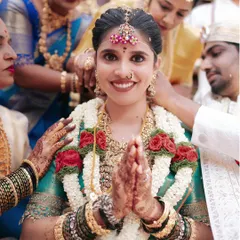 The heart of a South Indian wedding is in its traditions and family blessings. This candid shot captures the bride's joyful expression and the warmth of her loved ones, a moment of pure, unscripted happiness.