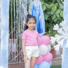 A happy little guest posing in front of our Elsa cutout and snowflake decorations. Creating these picture-perfect moments is what it's all about.