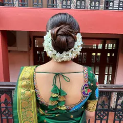 A perfect, neat bridal bun surrounded by a thick gajra of fresh jasmine. This is a timeless and fragrant choice for any traditional wedding ceremony.