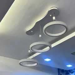 Another angle of the triple-ring chandelier, showing how it looks against the white false ceiling. The clean, modern design complements a minimalist interior style.
