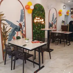Here is the final look of the Rajarammundry Rose Milk cafe. We designed the space to feel bright and welcoming, using custom tropical murals, a vertical garden wall with a neon sign, and a mix of seating to create a cosy atmosphere for customers.