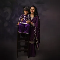 Laughter and love in matching outfits. This mother and daughter share a joyful moment, creating a beautiful memory captured in a classic, painterly portrait style.