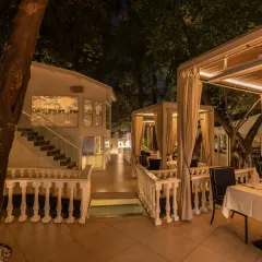 This wider view showcases the layout of our restaurant, with private cabanas nestled amongst the trees and elegant stairways leading to more secluded spots.