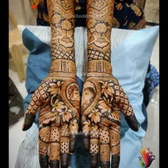 A close-up of a bride and groom portrait, nestled within a heart and surrounded by lotus flowers. This is a beautiful way to personalize your bridal mehndi.