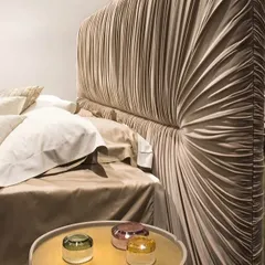 The art of texture and form. This bed features a dramatic, padded headboard with soft, sculptural drapery in a luxurious fabric. It's a testament to our meticulous craftsmanship, designed to be a stunning focal point that balances contemporary design with timeless comfort.