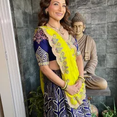A full-length photo showcasing her complete look. The makeup complements her vibrant outfit perfectly.