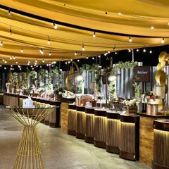We create magical ambiances with thoughtful lighting and decor. Draped ceilings with string lights cast a warm glow over our elegantly arranged food stations, perfect for an evening of celebration.