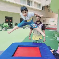 We encourage joyful movement and physical development in a safe, supervised environment. Here, a camper experiences the thrill of our gymnastics session, jumping with confidence on a trampoline under the watchful eye of our experienced instructor.