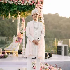 The groom stands proudly at his mandap, looking regal in his pastel sherwani. A moment of calm before the celebrations begin.