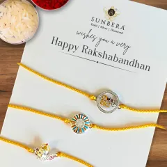 This flat lay showcases three of our popular silver rakhi designs for Rakshabandhan. The set includes a Ganesha motif, a modern circular design, and a 'Veera' rakhi, arranged with traditional rice and kumkum for the ceremony.