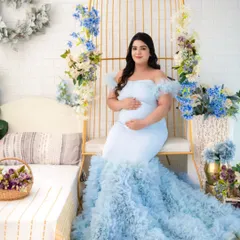 A fairy-tale moment in our light blue ruffled gown. The off-shoulder design and expansive train create a dreamy, ethereal look, especially when paired with our floral birdcage studio set.