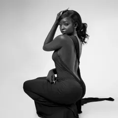 A striking black and white full-body shot. The pose, with the backless dress, creates a powerful and elegant silhouette, perfect for a high-fashion portfolio.