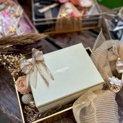Presenting a high-value gift like a Longines watch requires packaging that matches its prestige. I created this elegant tray for a travel trousseau, using soft fabrics and dried florals to create a secure and beautiful setting for the gift.