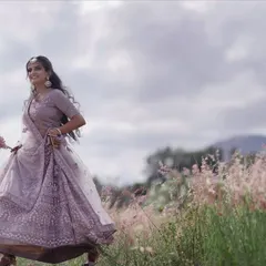 A beautiful, full-length shot from an outdoor pre-wedding session. Her soft, romantic makeup complements the light purple lehenga and the dreamy, natural setting. This look is all about ethereal elegance.