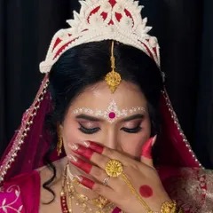 A coy pose from my Bengali bride, showing off her alta-colored hands and the beautiful chandan design.