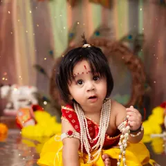 A wide-eyed and innocent portrait of a baby dressed as Lord Krishna for our Janmashtami special shoot.