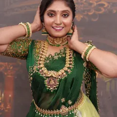 This is a vibrant half-saree look perfect for a pre-wedding celebration or portfolio shoot. The makeup features a bold eye and radiant skin to match the rich green and gold tones of the traditional attire.