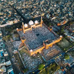 Another wide drone shot of Jama Masjid, capturing the overflow of worshippers into the streets surrounding the mosque.