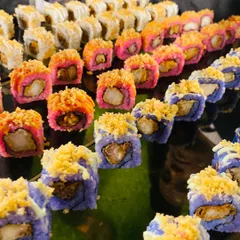 A close-up of our vibrant and artfully crafted sushi rolls. We offer a variety of fresh sushi, including prawn tempura and fish uramaki, presented beautifully to showcase the color and precision of Japanese cuisine.
