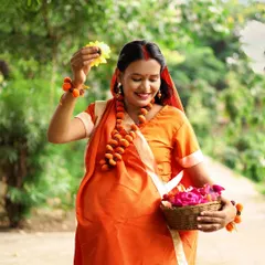 A solo portrait of the mother-to-be, dressed as Sita, with a basket of flowers. Her joyful expression and the traditional attire make this a beautiful, devotional image.