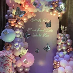 "Butterfly Kisses & Flower Petal Wishes." This elegant butterfly theme uses a soft lavender backdrop and an organic balloon garland in shades of pink, purple, and rose gold, accented with silver butterflies.