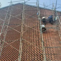 The intricate brick facade of the Brick House required immense skill and patience. This site photo shows our team of artisans carefully placing each brick to create the complex, woven pattern that defines the building's character.
