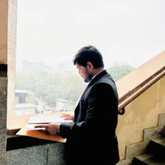 Reviewing case files by the window. Every opportunity, in court or out, is one I create through relentless preparation and attention to detail.