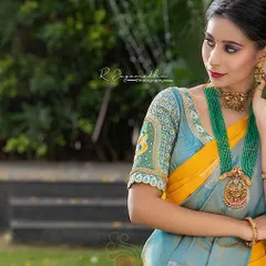 A beautiful light blue and yellow silk saree paired with a heavily embroidered blouse. This is a stunning combination for a daytime wedding or festive event.