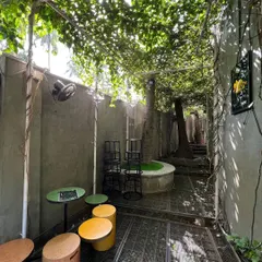 The view from within the Juhu green pocket, where a canopy of leaves creates a cool, shaded atmosphere. We designed this space with small seating areas, making it a perfect spot for customers to relax and enjoy a moment of peace in the city.