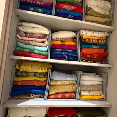 For sarees that are stored folded, we use shelf dividers to create neat, stable stacks. This prevents piles from toppling over and allows you to pull one out without disturbing the rest.