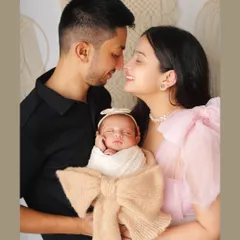 There's nothing more special than a family's first portrait. I captured this beautiful moment with the new parents adoring their sleeping newborn, who is wrapped snugly in a bow-adorned swaddle.