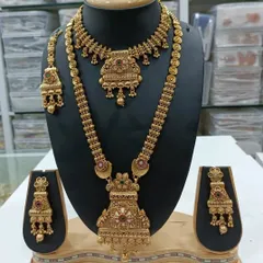 A classic antique gold finish combo set. It includes a short necklace and a long haar, both with a traditional design, perfect for pairing with silk sarees.