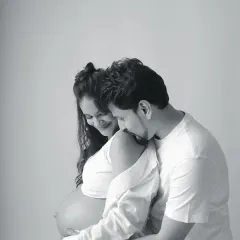 This black and white couple portrait is filled with tenderness. The way he rests his head on her shoulder while she cradles her bump creates a timeless and emotional photograph.