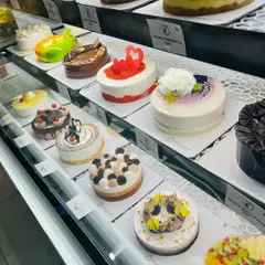 A look inside our display case, filled with a wide variety of cakes and cheesecakes. There's a flavor and style for every taste, ready for you to take home and enjoy.