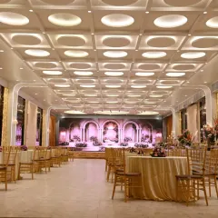 A wide view of a luxurious banquet hall in Vashi, set up for a reception. The modern ceiling lights and elegant round table arrangement create a sophisticated ambiance for any event.