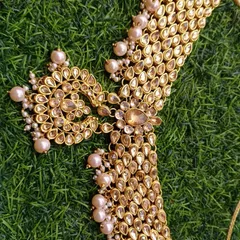 This image highlights the detail on a rental choker necklace with Kundan stones and pearl drops. It's a versatile piece that can be rented for a sangeet, reception, or as part of a wedding guest's ensemble.