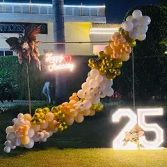 This shot shows the anniversary setup at dusk, with the neon sign and marquee number glowing beautifully in the garden setting.