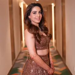 A close-up of this beautiful bride's reception look. Her soft makeup and elegant diamond necklace perfectly complement the sparkling brown lehenga, creating a look of pure joy and confidence.