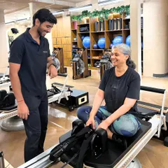 Every session is a partnership. Here, I'm working with a client to ensure her form is perfect and she feels supported. It’s this personalized guidance that makes all the difference, especially for those new to Pilates or rowing.