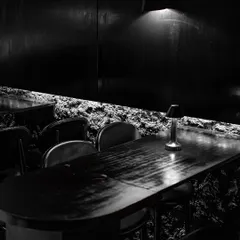 Dine in the mystique of a minimalist, modern-day den. The combination of raw, cave-like walls and sleek, dark furniture creates a uniquely sophisticated dining environment.