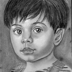 A charcoal portrait of a young boy, created on grey-toned paper. Using toned paper allows us to work with both dark charcoal and white highlights, which helps make the portrait pop and gives it a three-dimensional feel.
