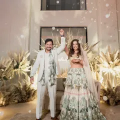 The happy couple celebrates their Roka ceremony amidst a shower of bubbles. The backdrop of pampas grass and soft lighting creates a dreamy, boho-chic atmosphere for this special moment.