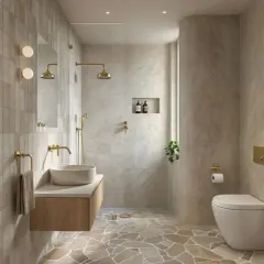 A bathroom design that uses natural stone flooring and textured tiles to create an earthy and organic feel. The gold fixtures add a touch of warmth and luxury.