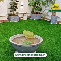 A simple yet elegant terrace setup combining high-quality artificial turf with a variety of potted plants, including a lotus bowl, to create a peaceful, green space.