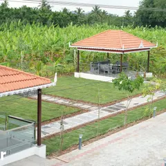 After: The same view, now a cohesive landscape. A lush lawn connects the main house to the gazebo, with neat stone pathways and newly planted trees beginning to define the space.