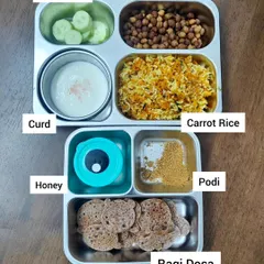 A child's lunchbox is more than just a meal; it's fuel for their day of learning and play. This balanced meal includes carrot rice for energy, boiled chana for protein, ragi dosa for essential nutrients, and fresh cucumber and curd to keep things cool and refreshing.